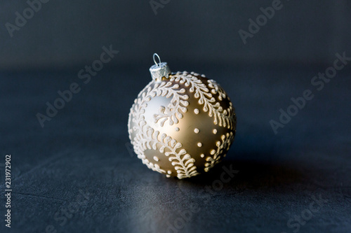 Gold pearl. Gold sphere on dark background. Holiday christmas toy for fir tree.