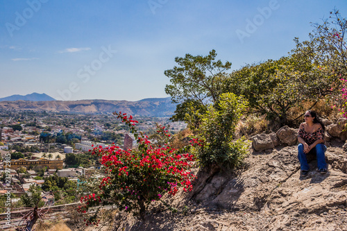 beautiful view of a woman sitting on a rock looking towards the village in Tequila Mexico, copy space