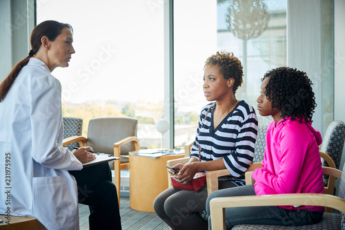 Doctor speaks with mother and daughter at an appointment