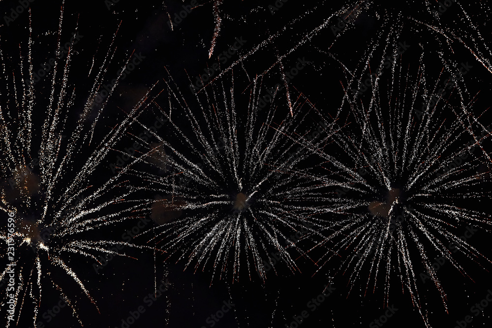Obraz premium Fireworks in the night sky. Texture salute. Abstract photo of flares on a black background. Photos of lights salute in the sky. Image of salute flashes. Texture of colored lights.