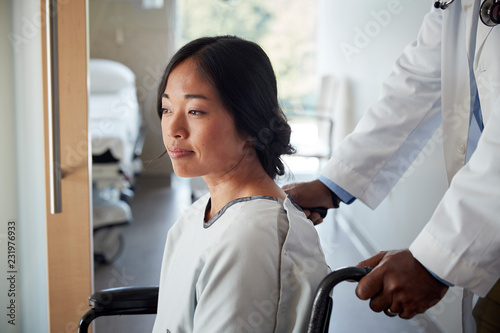 Doctor pushing woman in wheelchair