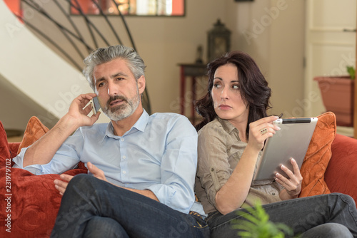 Unsure wife is looking at her husband talking on the phone