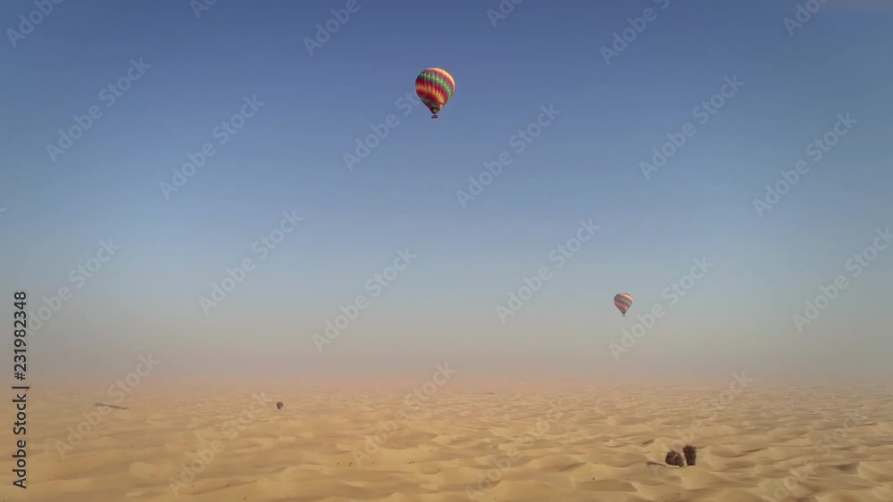 Aerial view of hot-air-balloon flying in the clouds of the Murqquab desert in Dubai, U.A.E. Aerial view of hot-air-balloon flying in the clouds of the Murqquab desert in Dubai, U.A.E.