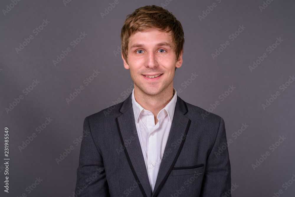 Portrait of young handsome businessman against gray background Portrait of young handsome businessman against gray background