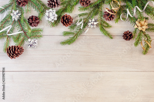 Composition of fir branches decorated with cones  bows and ribbons  on a light background. Copy space.