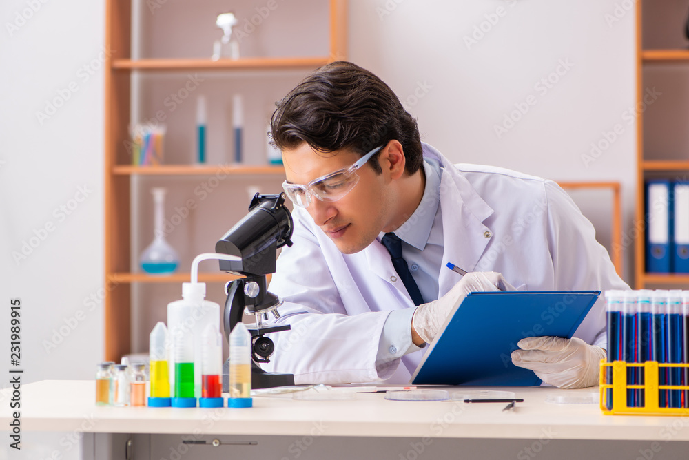 Young handsome biochemist working in the lab Young handsome biochemist working in the lab