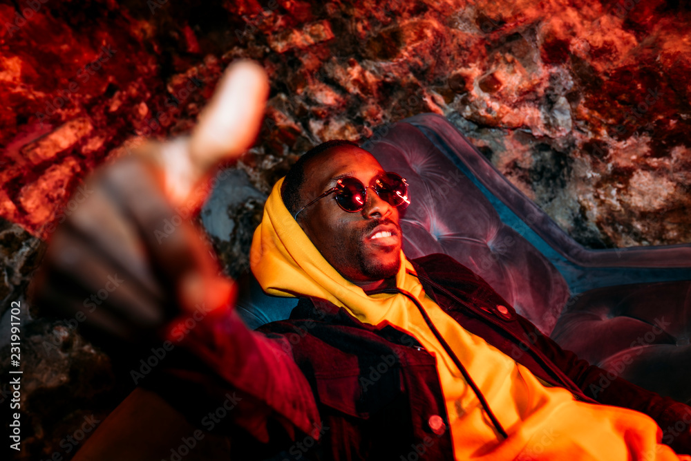 African man rapper among colorful light. Long exposure - obrazy, fototapety, plakaty 