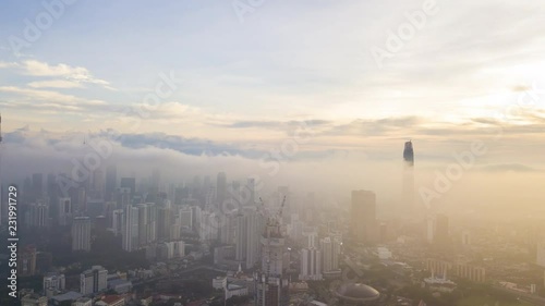 4k hyper lapse dronelapse aerial view of sunrise at Kuala Lumpur city skyline.  Tilt up photo