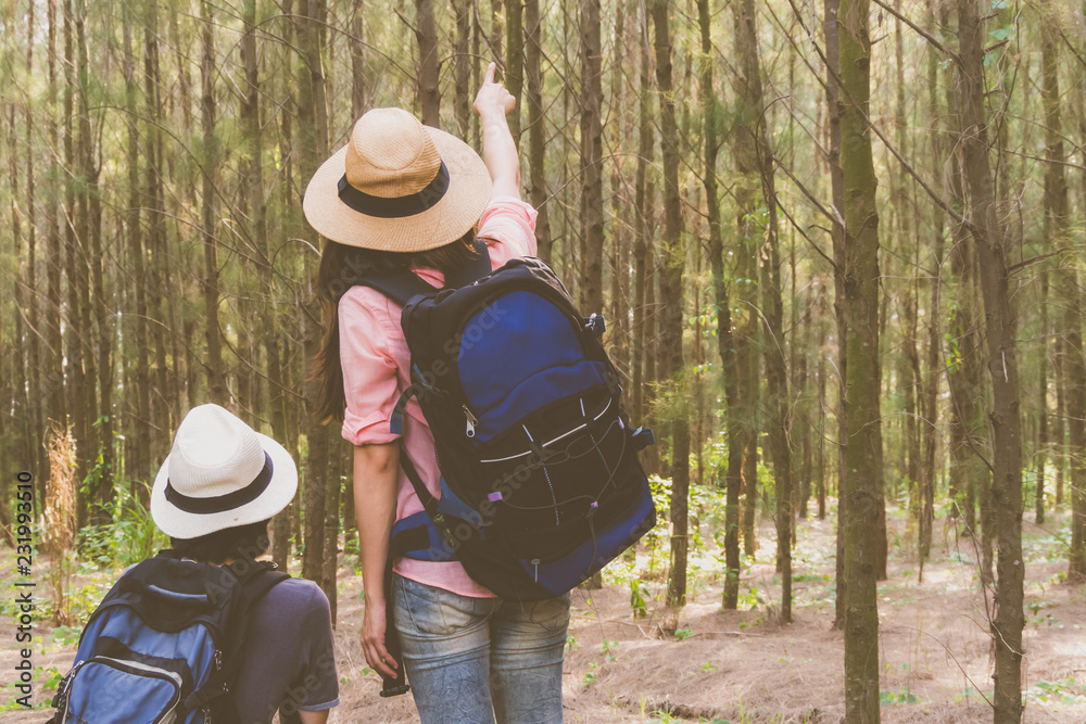 Couple traveler in forest pointing to them traget and exciting with adventure on holiday.