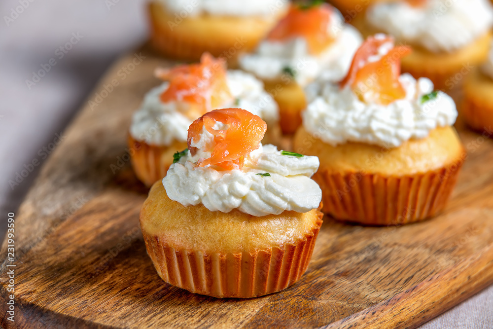Muffin with salmon with whipped cream and cheese on wooden board, selective focus. Muffin with salmon with whipped cream and cheese on wooden board, selective focus.