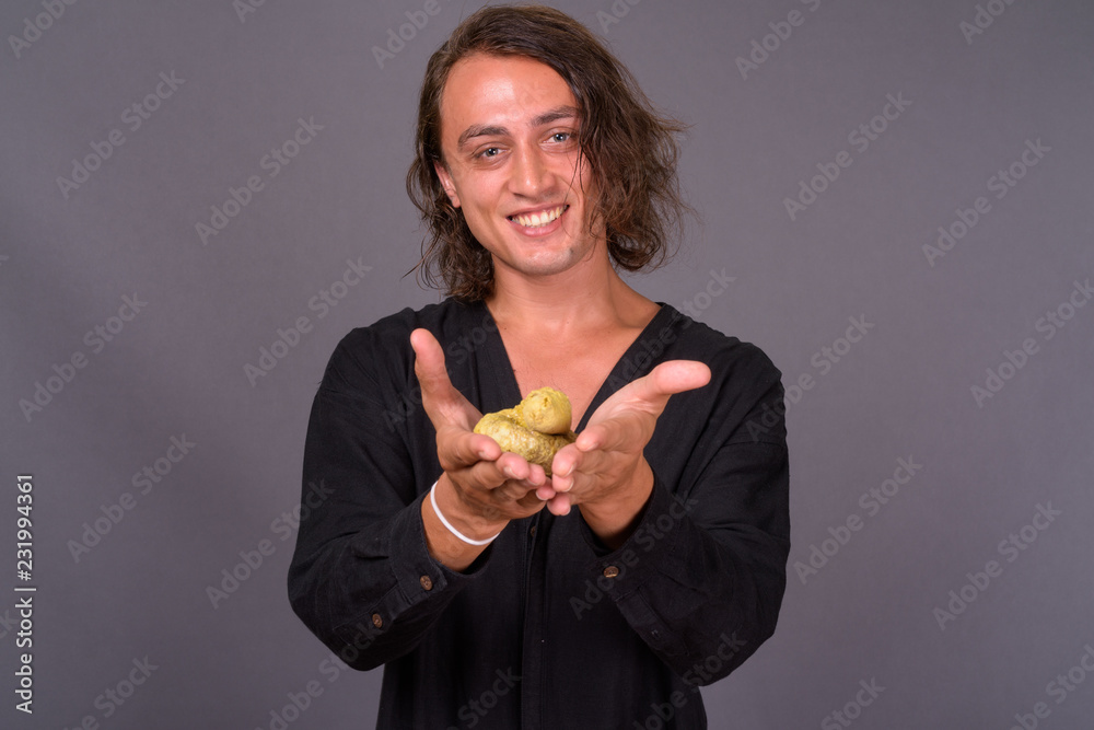 Portrait of happy young man smiling and holding poo