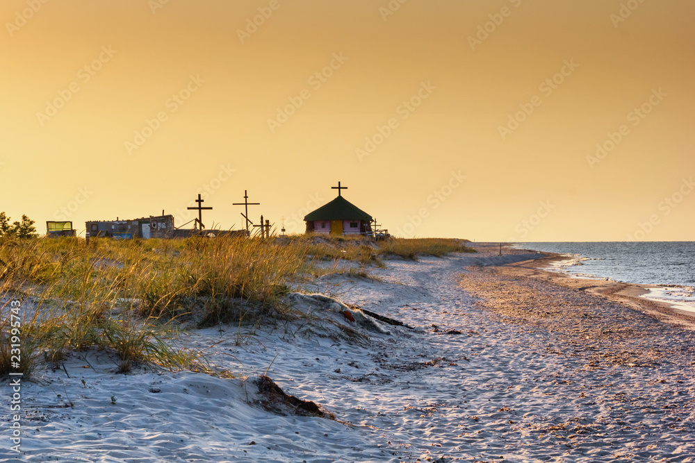 Seaside landscape - sunrise on the seashore with Orthodox Skete against the background of an summer sky