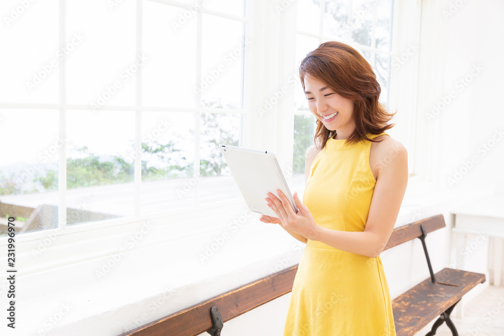 部屋でタブレットを見る女性 部屋でタブレットを見る女性