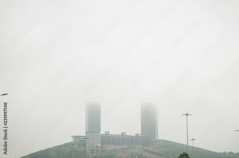 two buildings on a mountain with a lot of fog around them