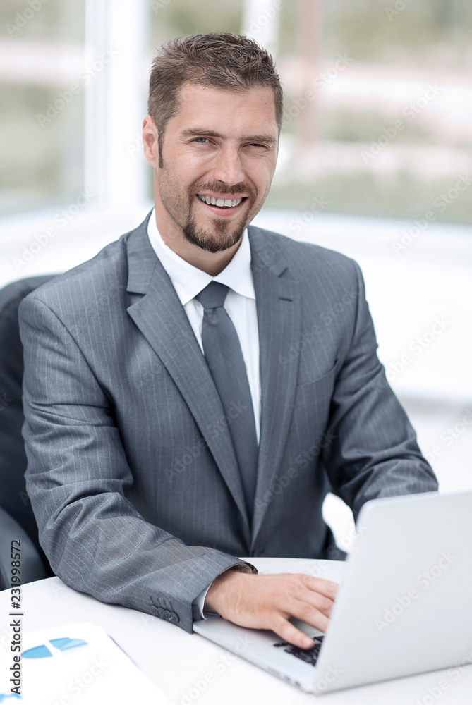 closeup.smiling businessman working with laptop