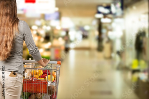 Woman with cart shopping in supermarket