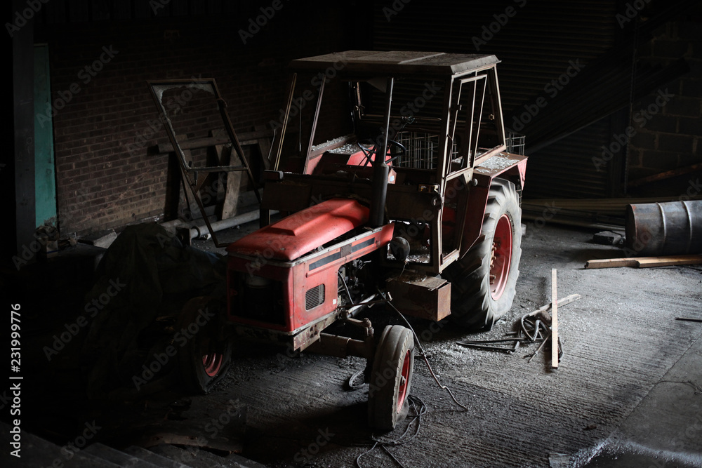 tractor lit from side in old barn