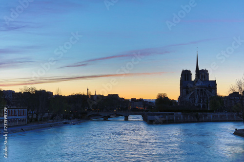 Paris, France - April 3, 2018: Notre dame de Paris cathedrale viewed from Tournelle bridge at dusk