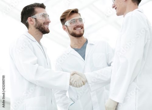 blurred image of a handshake between scientists