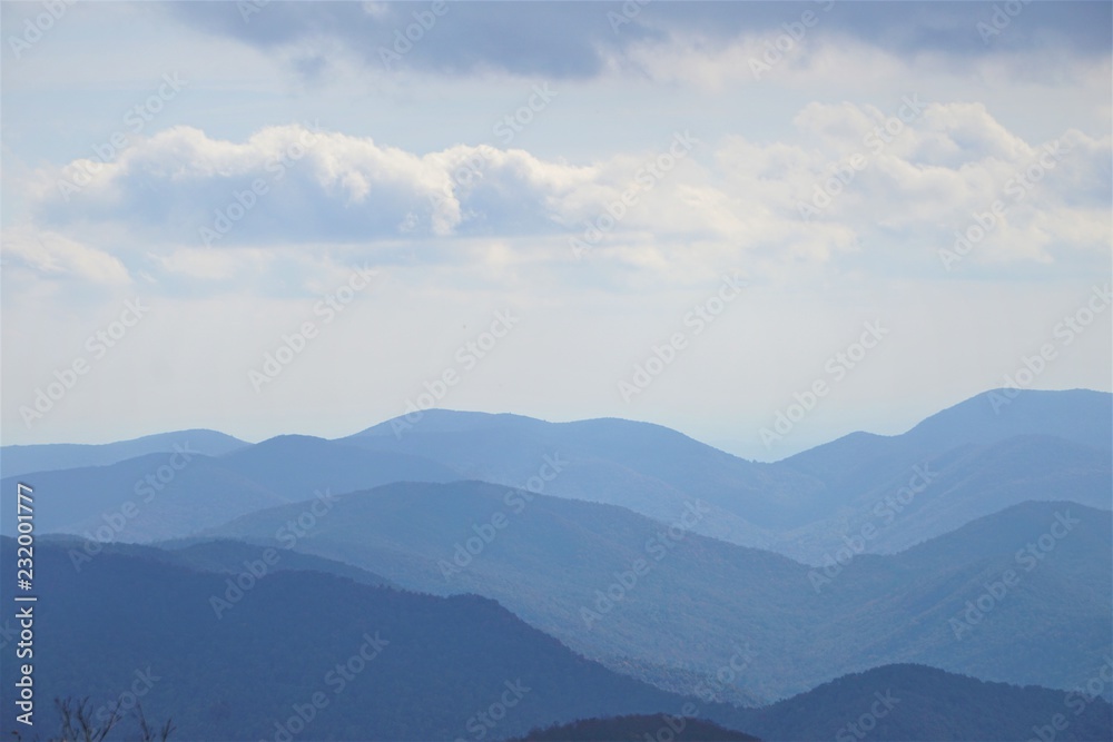 The fantastic view from Brasstown Bald mountain ( the highest mountain in Georgia) on a hazy day, mountains looks silhouette with white fluffy clouds and blue sky, North Georgia in USA. The fantastic view from Brasstown Bald mountain ( the highest mountain in Georgia) on a hazy day, mountains looks silhouette with white fluffy clouds and blue sky, North Georgia in USA.