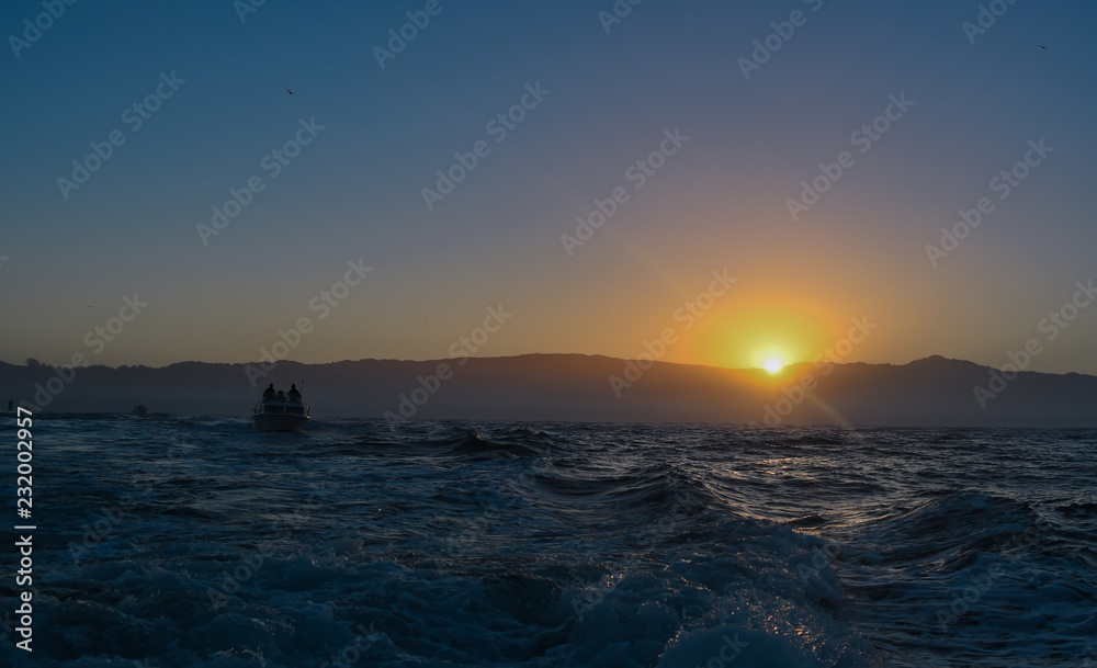 Boaters heading to the open sea in the early morning with a beautiful sunrise
