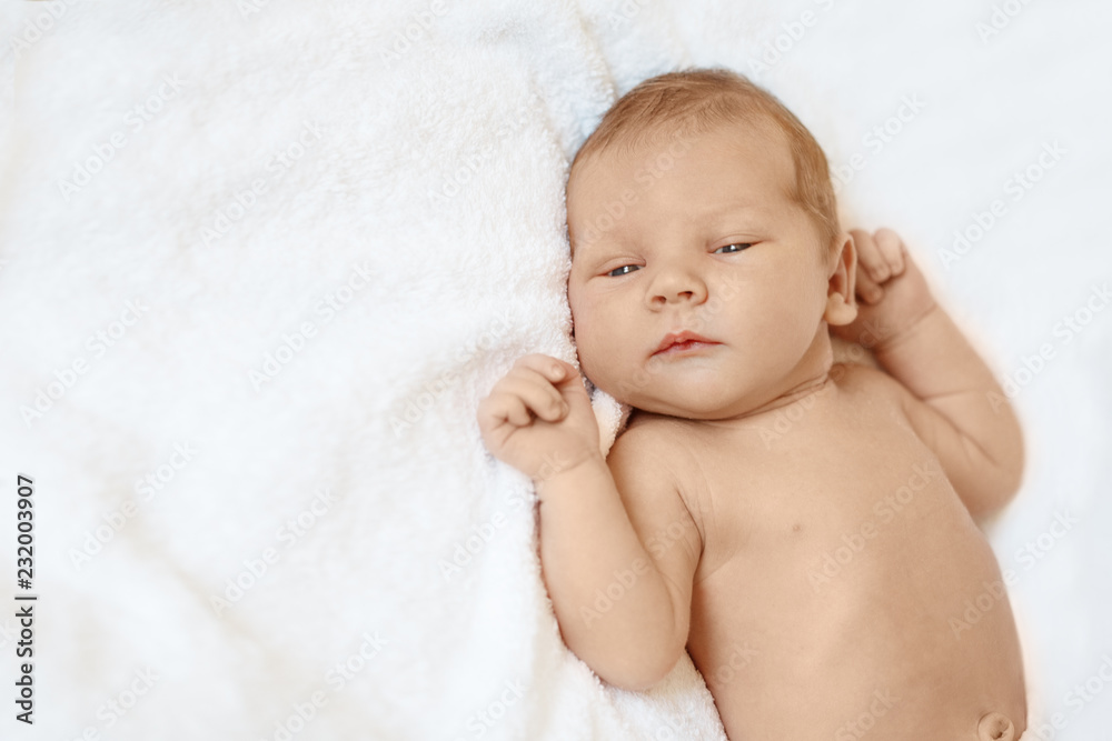 Little newborn baby boy sleeping in white blanket, lying on bed. Little newborn baby boy sleeping in white blanket, lying on bed.