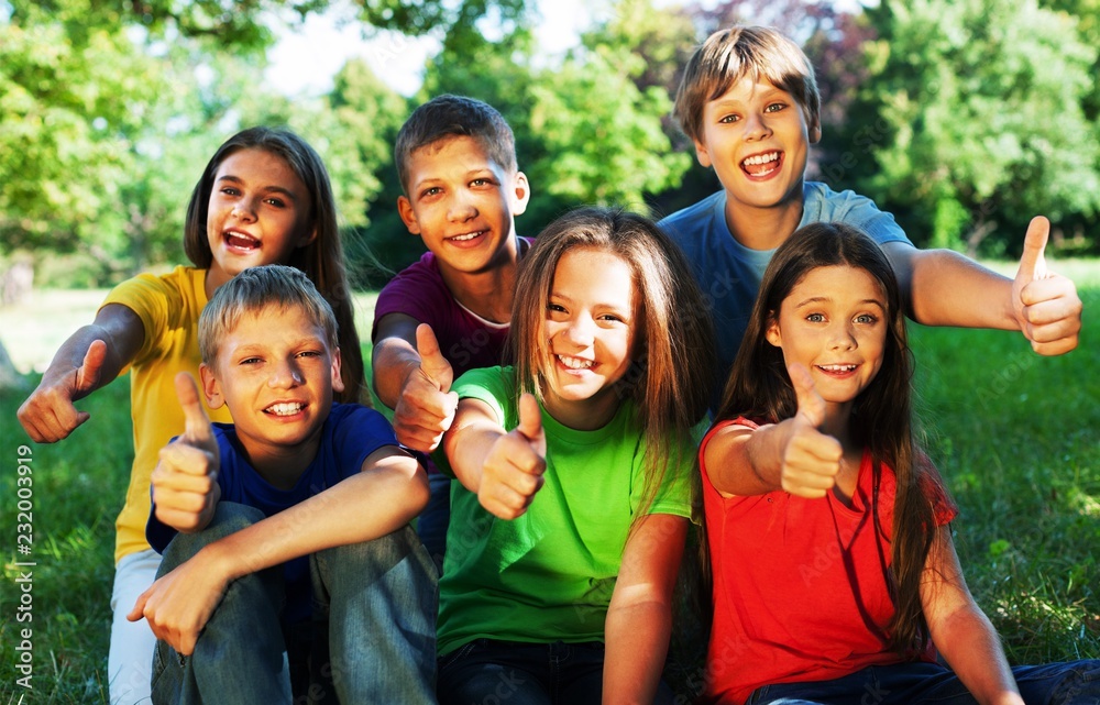 Fototapeta premium Happy smiling diverse kids hugging in park