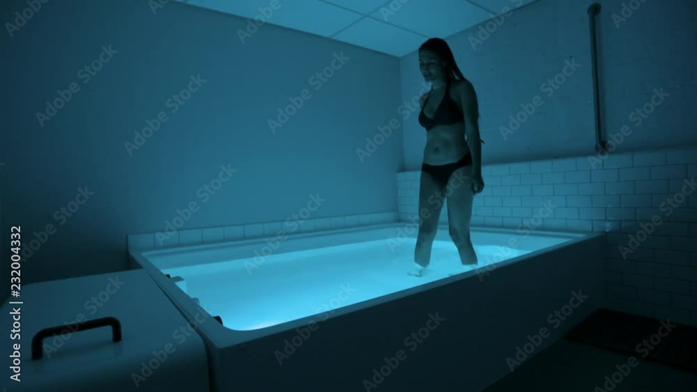 Young Woman in float tank, sensory depravation tank at spa