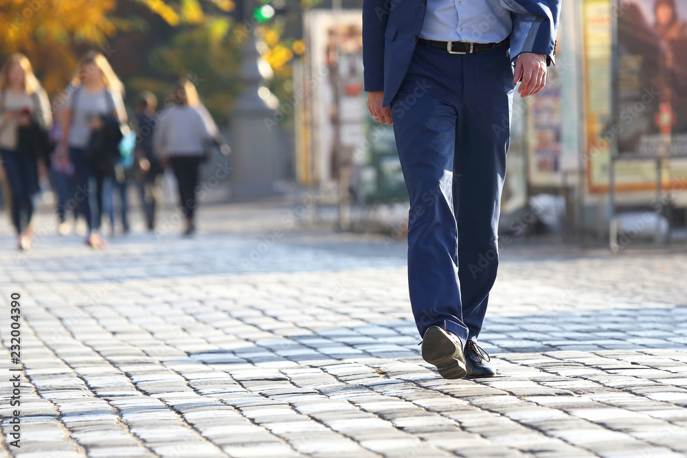 business man crossing the road at a pedestrian crossing on the pavement business man crossing the road at a pedestrian crossing on the pavement