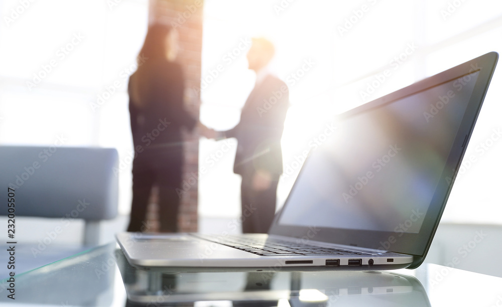 laptop on the desk, background handshake laptop on the desk, background handshake