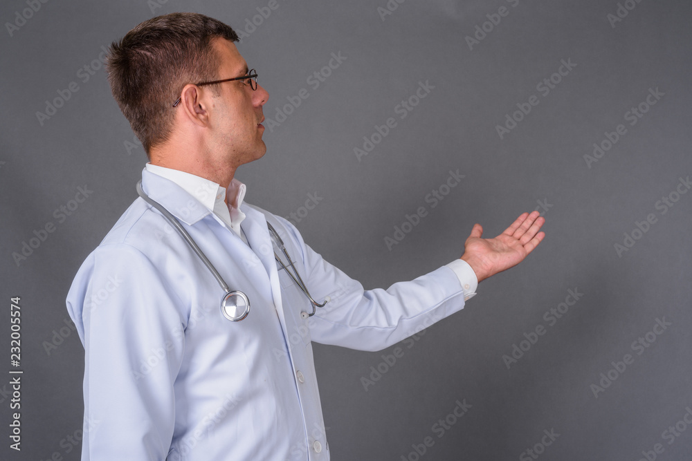 Handsome man doctor with short hair against gray background Handsome man doctor with short hair against gray background