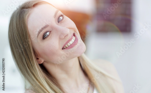 close-up portrait of a young woman on a blurred office background.