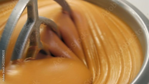 Close up shot of delicious peanut butter mixing in large bowl