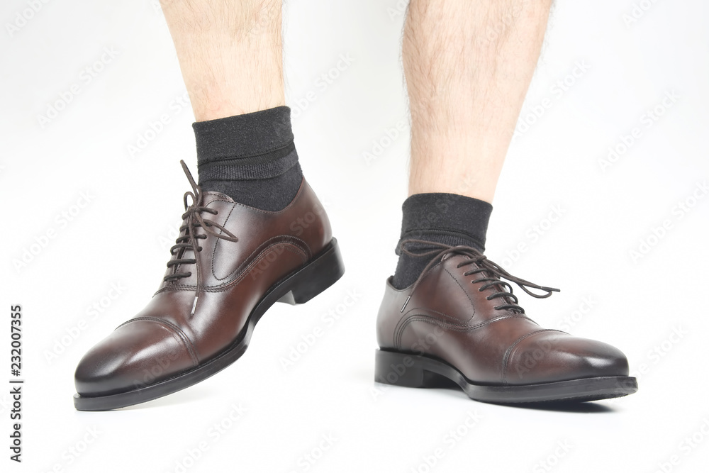 naked legs of a man in classic brown shoes