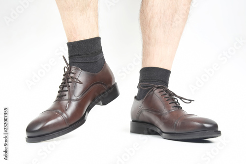 naked legs of a man in classic brown shoes