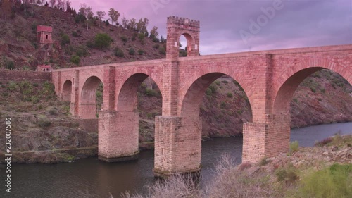 Cinematic wide tracking shot of Alc√°ntara Bridge at sunset photo