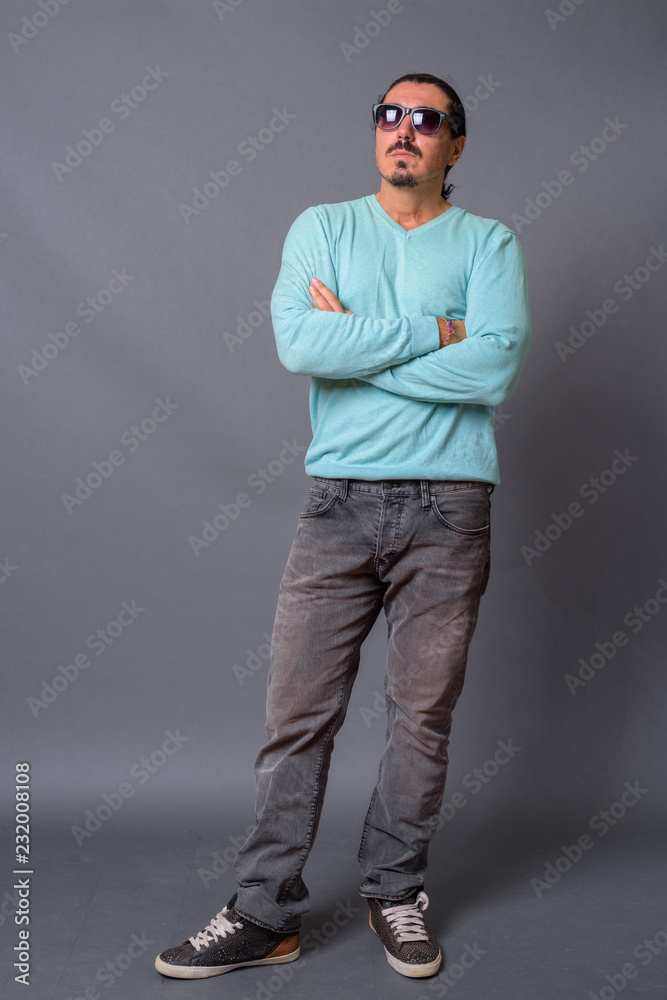 Handsome man with curly hair and mustache against gray backgroun Handsome man with curly hair and mustache against gray backgroun