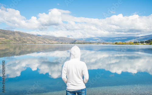 Tourist standing and looking to the spectacular reflection of lake Dunstan in Cromwell, New Zealand. photo