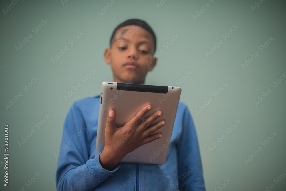 Kid holding tablet while reading Kid holding tablet while reading