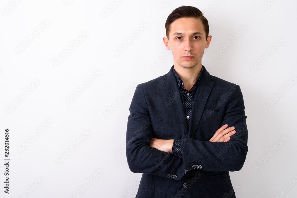 Studio shot of young handsome businessman with arms crossed agai Studio shot of young handsome businessman with arms crossed agai