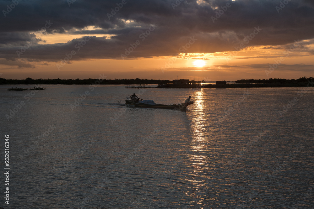 magical sunset on the lake with backlight boat