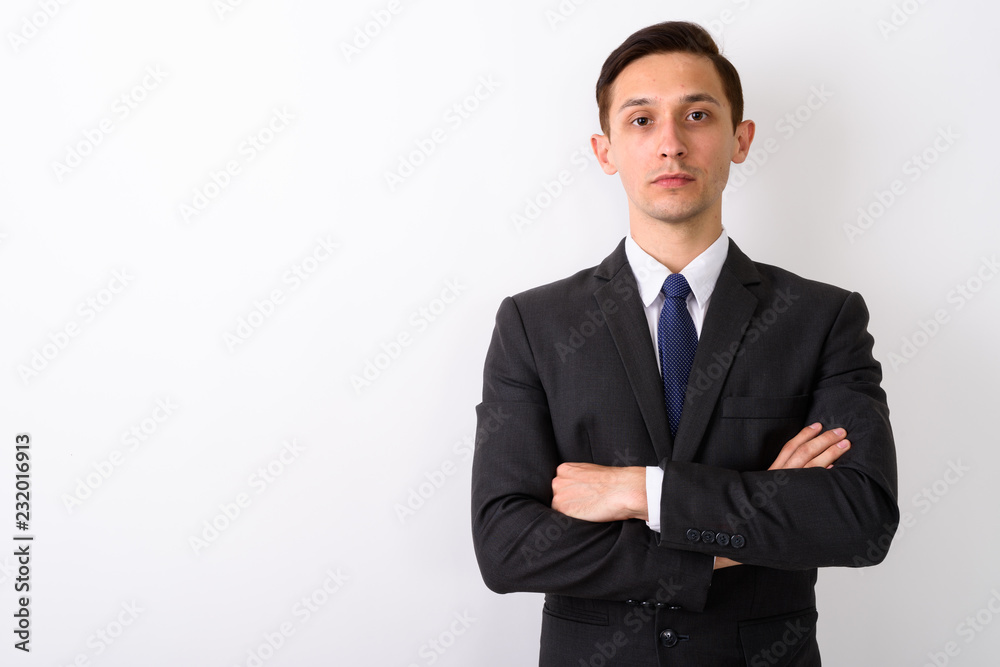Studio shot of young handsome businessman with arms crossed agai Studio shot of young handsome businessman with arms crossed agai
