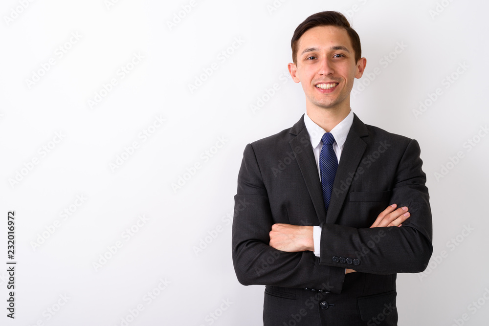 Studio shot of young happy businessman smiling with arms crossed Studio shot of young happy businessman smiling with arms crossed