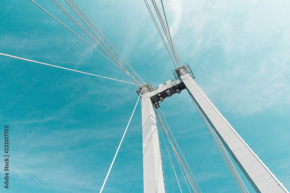 Fototapeta premium cable-stayed bridge closeup against a blue cloudy sky , abstract structure background