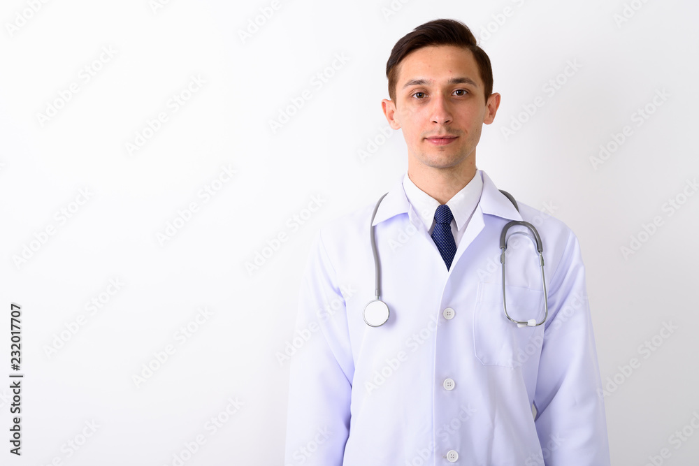 Studio shot of young handsome man doctor against white backgroun Studio shot of young handsome man doctor against white backgroun