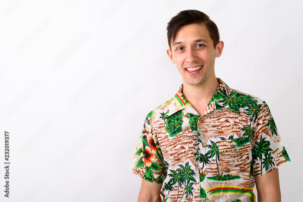 Studio shot of young happy tourist man smiling against white bac Studio shot of young happy tourist man smiling against white bac