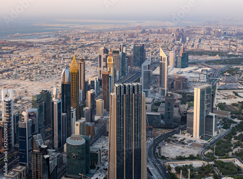 Aerial city view with crossroads, roads, buildings, skyscrapers, parking lots. Afternoon before sunset. Helicopter shot. 