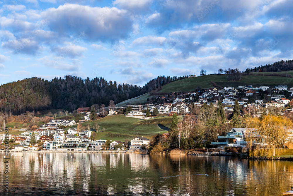Φωτογραφία Lovely village by lake, among green hills of Switzerland.