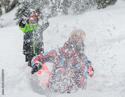 Cheerful family playing with snow drift, winter holidays, front view, snow in the air
