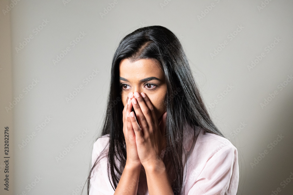 Woman of Color Looking Concerned, covering face with hands in disbelief Woman of Color Looking Concerned, covering face with hands in disbelief